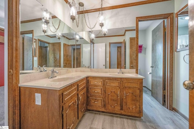full bathroom featuring a sink, crown molding, double vanity, and wood finished floors