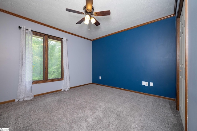empty room featuring crown molding, baseboards, a ceiling fan, and carpet floors
