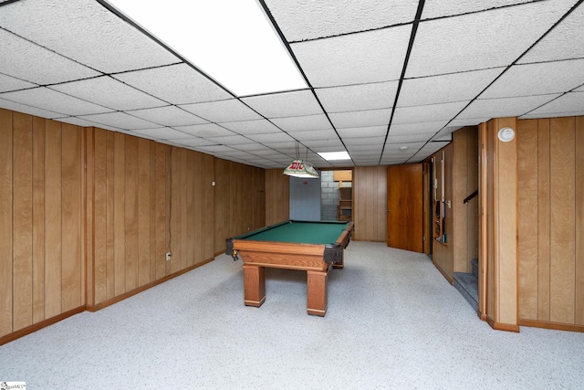 recreation room with a paneled ceiling, light carpet, wood walls, baseboards, and billiards