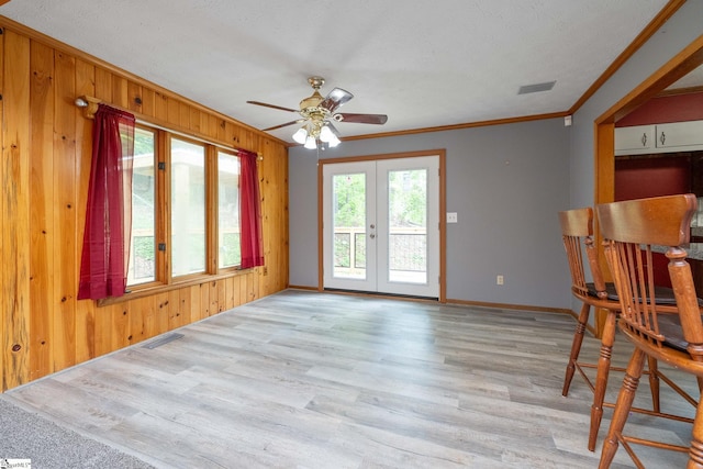 unfurnished room featuring a ceiling fan, light wood finished floors, visible vents, and crown molding