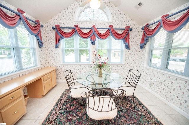 dining room featuring lofted ceiling, a wealth of natural light, and wallpapered walls