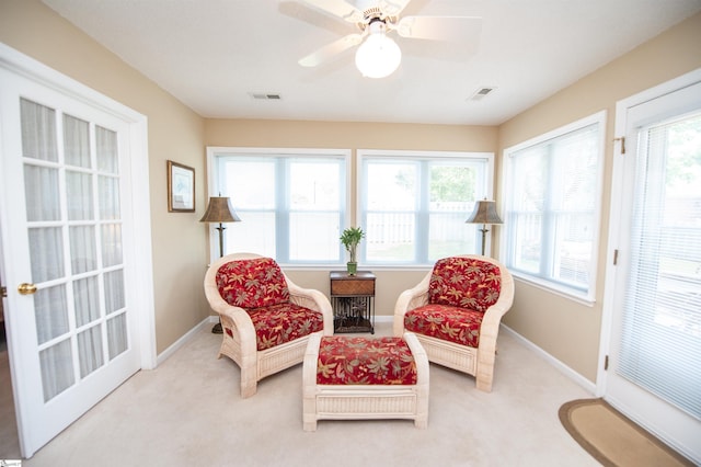 living area with plenty of natural light, visible vents, and light carpet