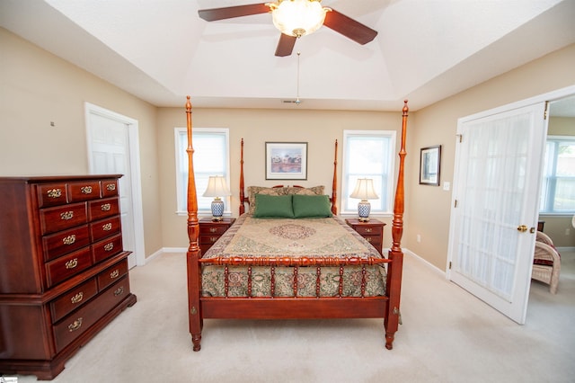 bedroom with light colored carpet, multiple windows, baseboards, and a ceiling fan