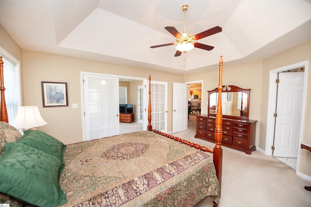 bedroom featuring french doors, light colored carpet, ceiling fan, a raised ceiling, and baseboards