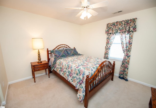 bedroom with baseboards, a ceiling fan, visible vents, and light colored carpet