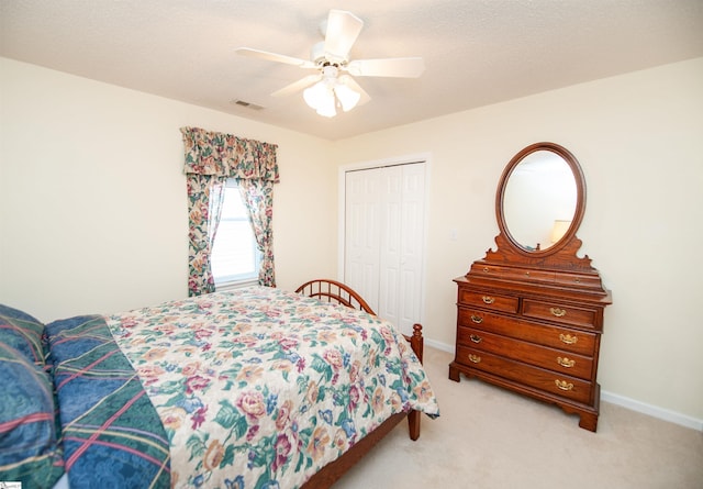bedroom featuring a ceiling fan, a closet, baseboards, visible vents, and light carpet