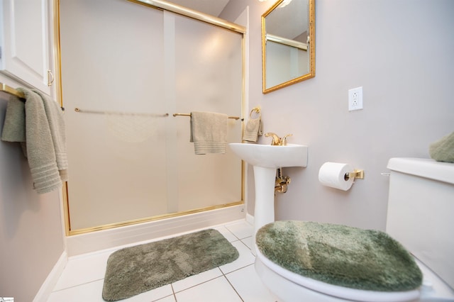 bathroom featuring tile patterned floors, toilet, baseboards, and a stall shower