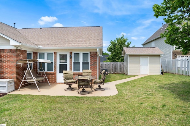 view of yard with a fenced backyard, a patio area, a storage unit, and an outbuilding