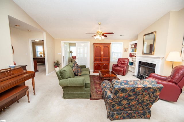 carpeted living room featuring ceiling fan, baseboards, and a high end fireplace