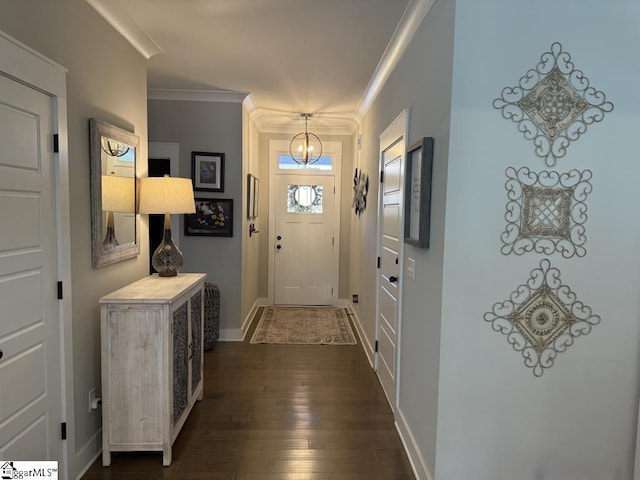 doorway to outside with crown molding, dark wood-style flooring, a notable chandelier, and baseboards