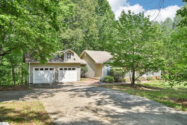 obstructed view of property with aphalt driveway, an outdoor structure, and a garage