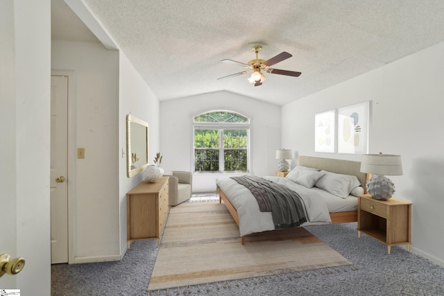 bedroom with lofted ceiling, a textured ceiling, baseboards, and carpet floors