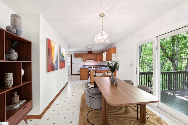 dining room with baseboards, light floors, and a notable chandelier