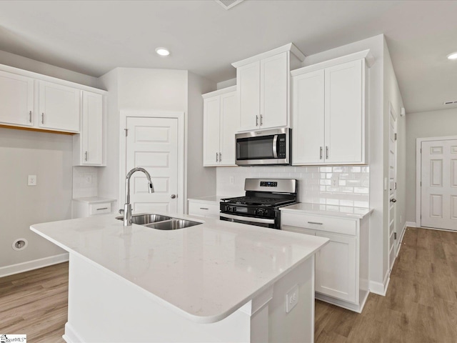 122 Arrow Ct, Greer, SC 29651 - kitchen featuring appliances with stainless steel finishes, a center island with sink, white cabinets, light wood-type flooring, and recessed lighting
