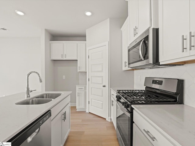 124 Arrow Ct, Greer, SC 29651 - kitchen featuring stainless steel appliances, white cabinetry, light wood-style flooring, backsplash, and recessed lighting