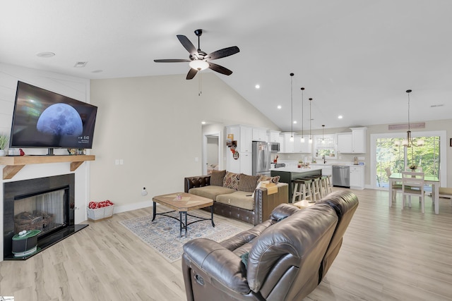 555 Canewood Ln, Campobello, SC 29322 - living room with baseboards, ceiling fan, high vaulted ceiling, light wood-style floors, and a fireplace