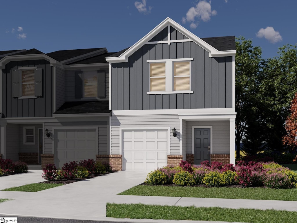 view of front of home with concrete driveway, a garage, brick siding, and board and batten siding