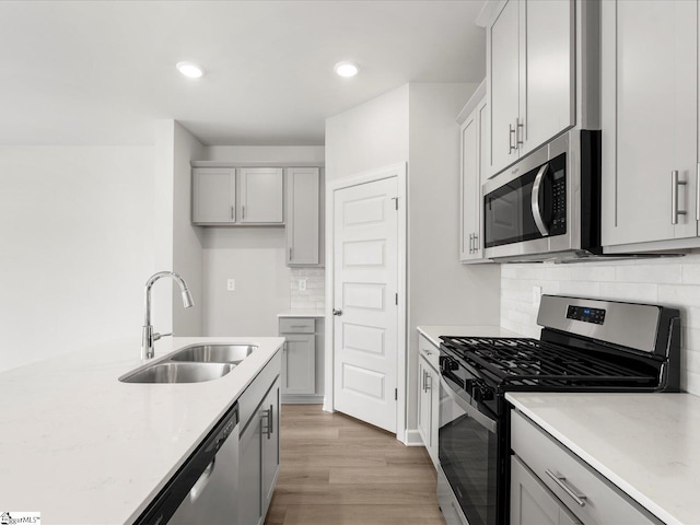 126 Arrow Ct, Greer, SC 29651 - kitchen with appliances with stainless steel finishes, gray cabinetry, light wood-type flooring, decorative backsplash, and recessed lighting