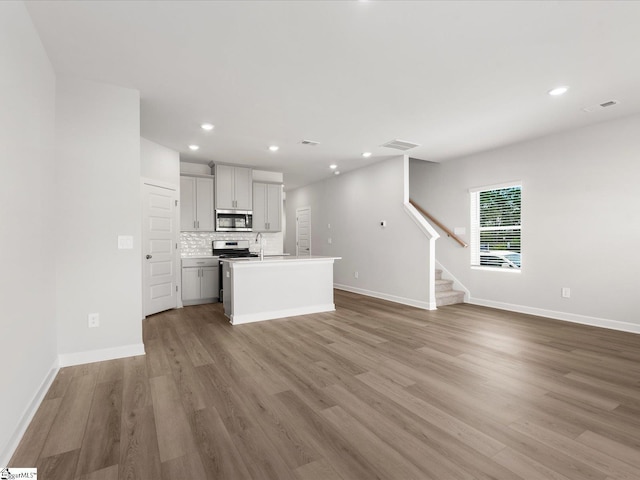 126 Arrow Ct, Greer, SC 29651 - unfurnished living room with stairs, light wood-type flooring, and recessed lighting