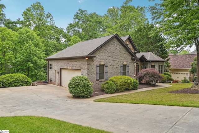 view of front of home featuring concrete driveway, a front lawn, brick siding, and an attached garage