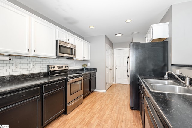 301 Glenlea Ln, Greenville, SC 29617 - kitchen featuring a sink, white cabinetry, backsplash, light wood-style floors, and appliances with stainless steel finishes