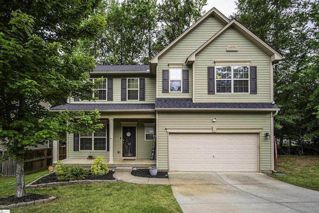 view of front of house with covered porch, a garage, fence, concrete driveway, and a front yard
