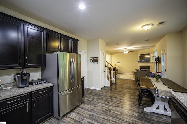 kitchen featuring appliances with stainless steel finishes, a fireplace, dark wood-style floors, and dark cabinets