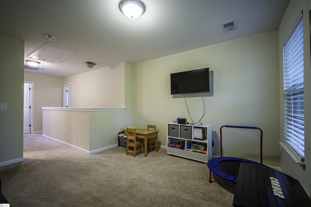 recreation room featuring baseboards, visible vents, attic access, and carpet floors