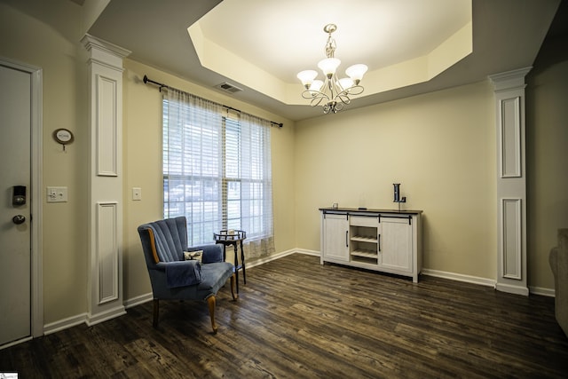 living area featuring baseboards, dark wood-style flooring, an inviting chandelier, visible vents, and ornate columns