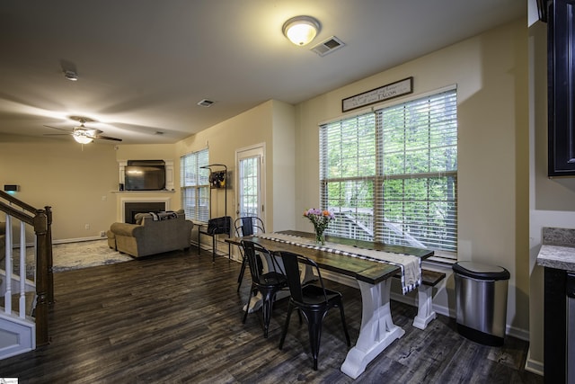 dining space with baseboards, dark wood-style flooring, visible vents, stairs, and a fireplace