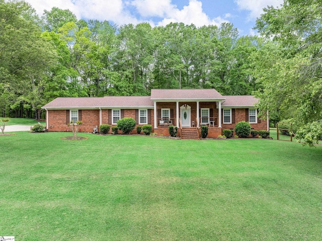 view of front of home with covered porch, brick siding, and a front yard