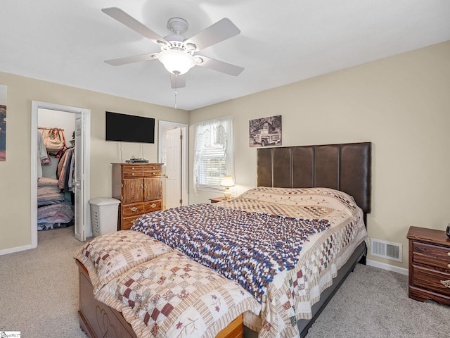 carpeted bedroom with a ceiling fan, a closet, baseboards, visible vents, and a spacious closet