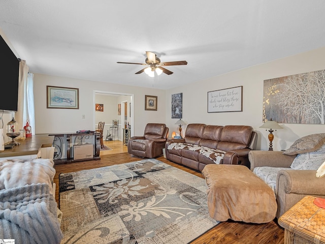 living area with wood finished floors and ceiling fan
