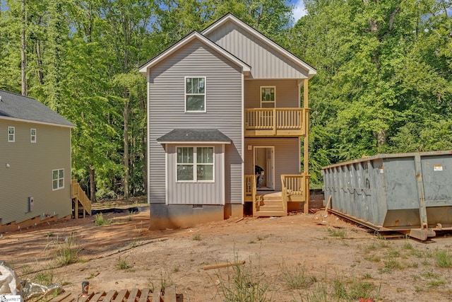 back of house featuring a wooden deck and a balcony