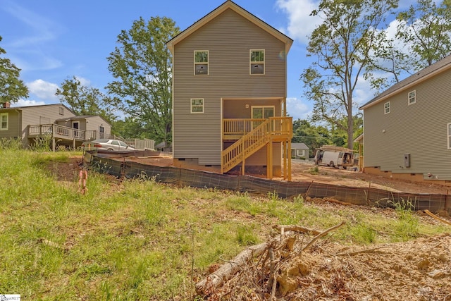 rear view of house featuring a deck, fence, and crawl space