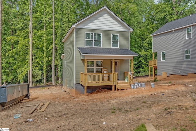 view of front of home with roof with shingles and a deck