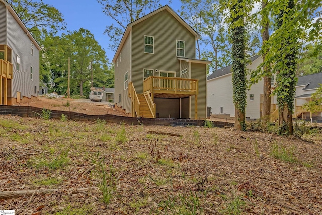 back of house with stairway, a wooden deck, and fence