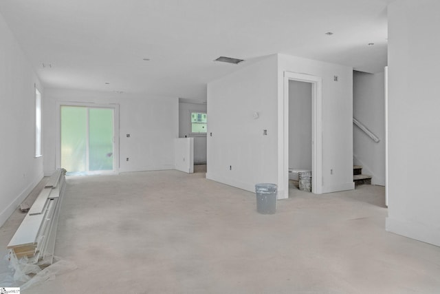 unfurnished living room with visible vents and stairs