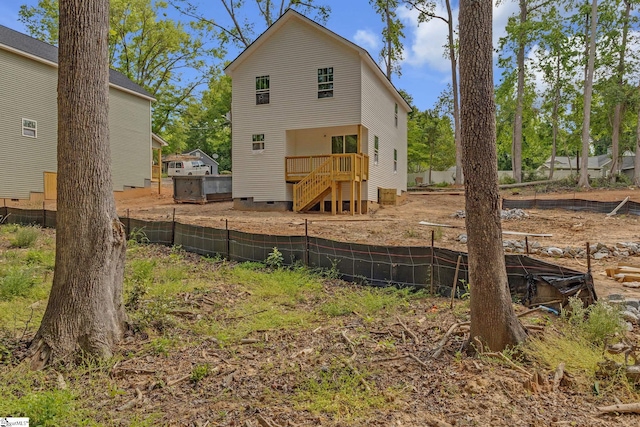 rear view of house featuring a wooden deck, fence, and crawl space