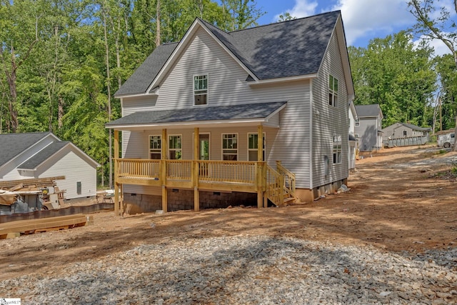 rear view of house with a porch and a shingled roof
