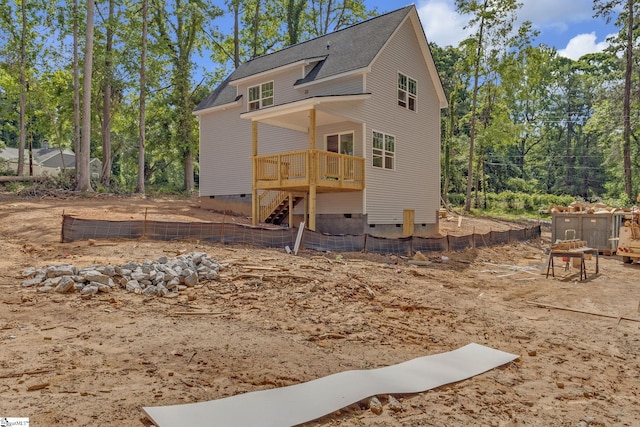 back of house featuring roof with shingles, crawl space, fence, and a wooden deck