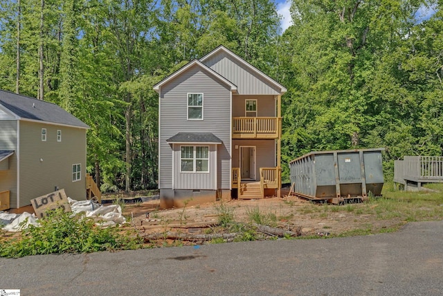 traditional-style house with crawl space, board and batten siding, a wooden deck, and a balcony