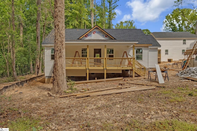 rear view of property featuring a wooden deck, roof with shingles, and crawl space