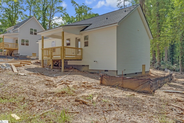 rear view of property featuring a deck, a shingled roof, fence, and crawl space