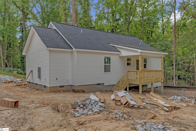 view of front facade with a deck, a shingled roof, and crawl space