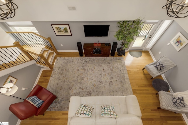 living room featuring an inviting chandelier, visible vents, and wood finished floors