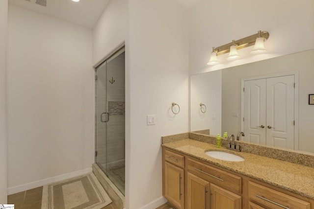 full bathroom with vanity, baseboards, a shower stall, and tile patterned flooring