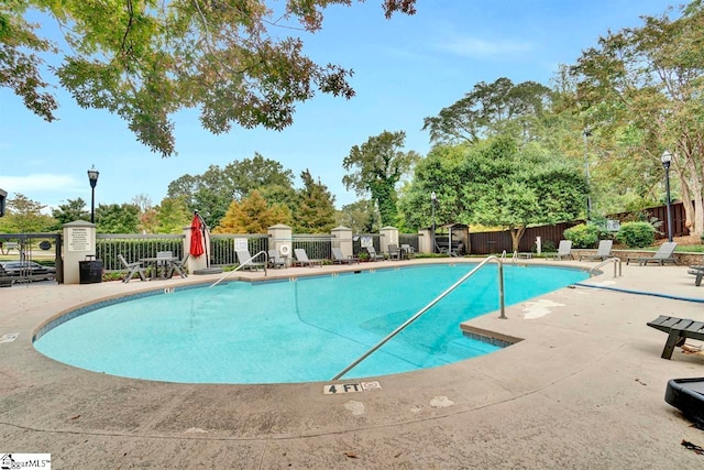 pool with fence and a patio