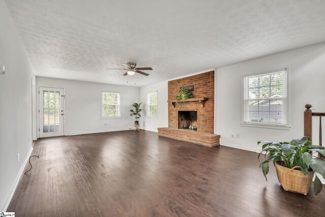 5 Huntley Castle Ct, Taylors, SC 29687 - unfurnished living room with a ceiling fan, a brick fireplace, a textured ceiling, dark wood-type flooring, and baseboards