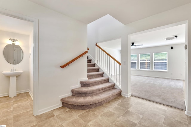 stairway featuring a ceiling fan, baseboards, visible vents, and carpet floors